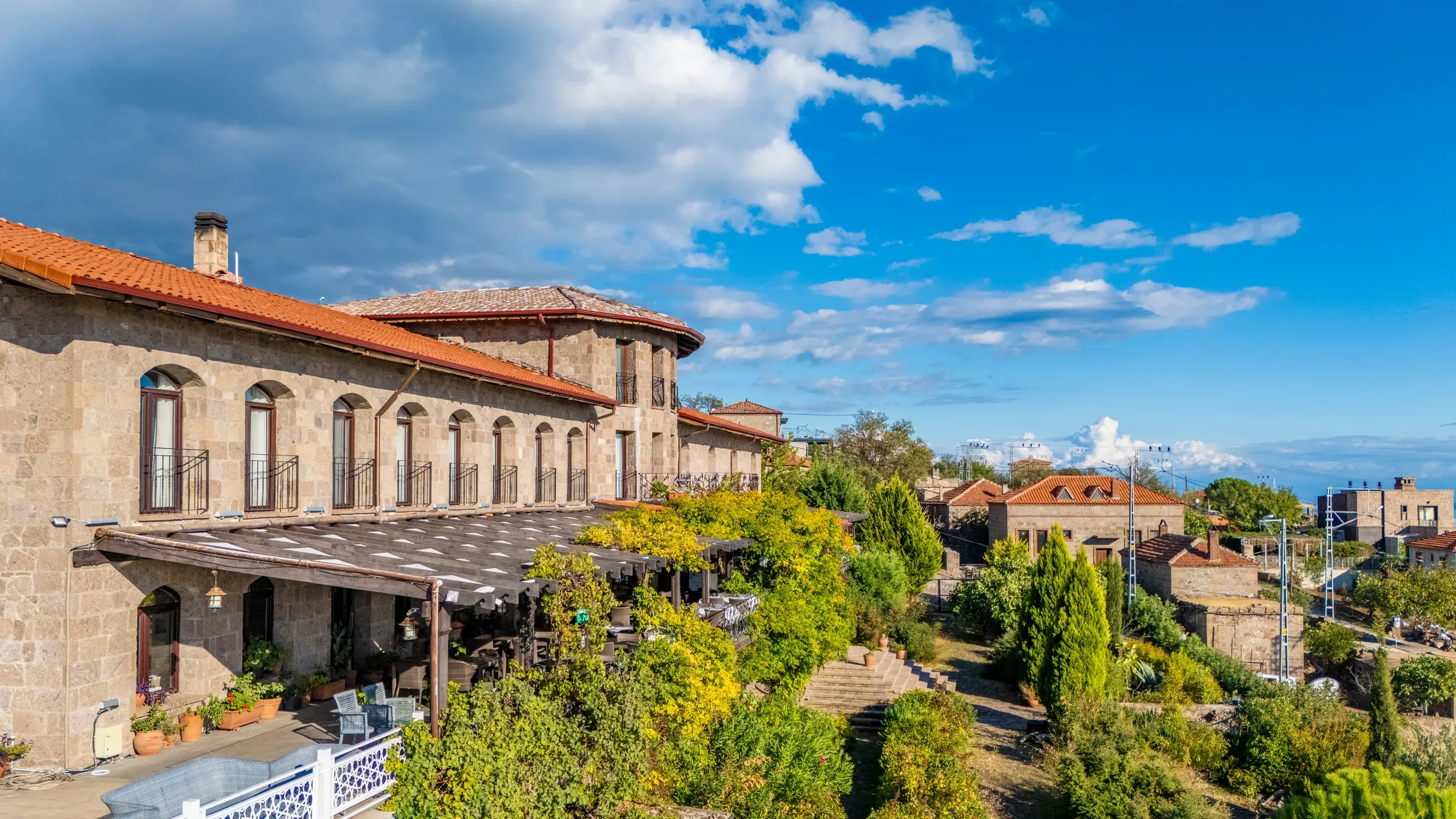 Taş binanın önünde pergolalı restoran terası